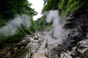秋田県湯沢市・小安峡、渓谷沿いの川と遊歩道の脇から湯気が立ち上る幻想的な温泉地の風景（撮影:Nikon Z6III）