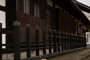 山形・東光の酒蔵、木柵越しに望む歴史を感じる建造物（撮影:Nikon Z50）