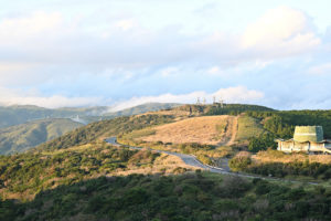 静岡・伊豆スカイライン、夕方の柔らかな光に包まれ、遠くの空で雲が黙々と浮かぶワインディングロード（撮影:Nikon Z50）